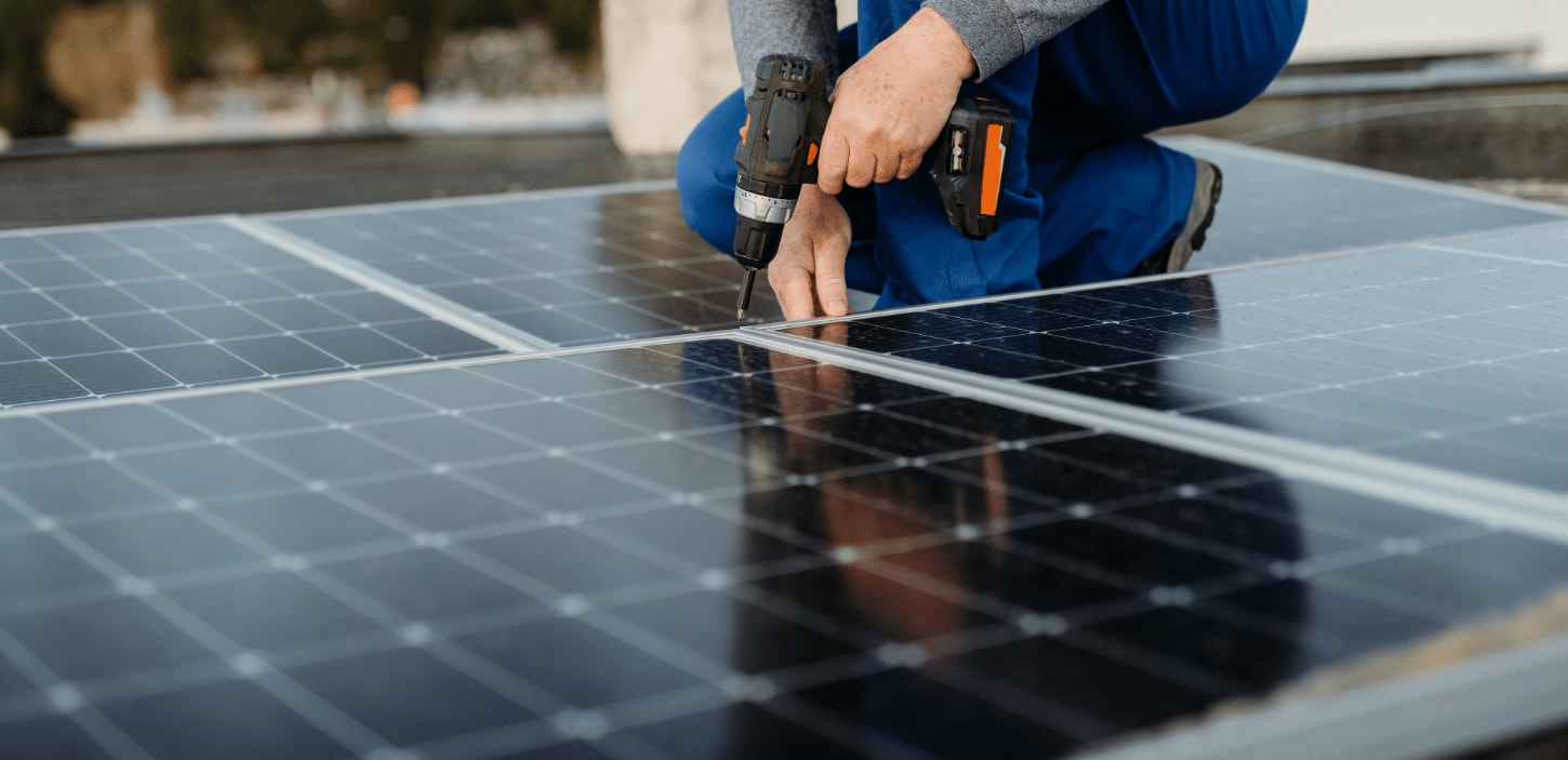 Técnico de O&G fijando la estructura de un panel solar con un taladro